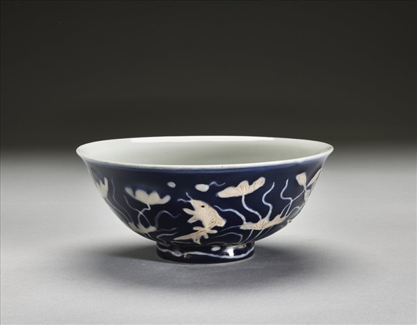 藍地堆白蓮塘游魚紋碗
