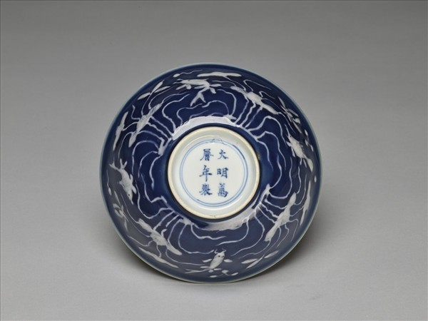 藍地堆白蓮塘游魚紋碗