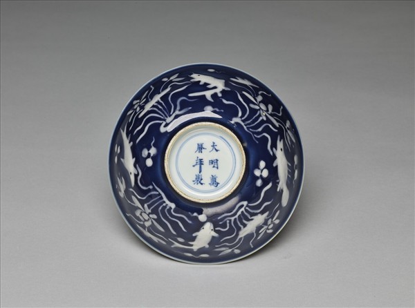 藍地堆白蓮塘游魚紋碗