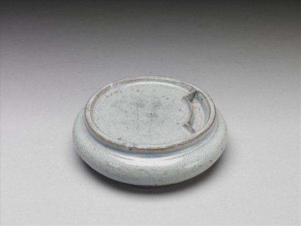 Round porcelain inkstone in moon-white glaze (with a jade-inlaid case) by Unknown artist